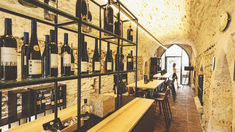 Weinviertler Weine, © Michael Reidinger Weinkeller mit Flaschenregalen und Tischen in einem Gewölbe.