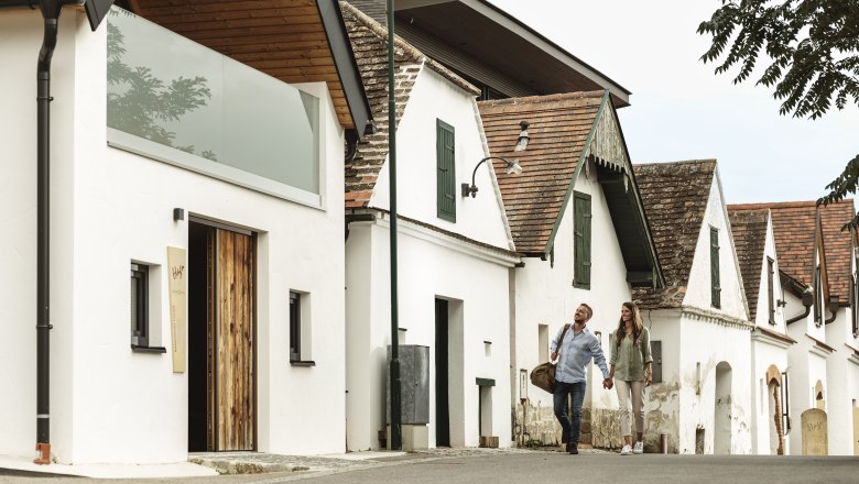 Vinárstvo Hagn Kellerstöckl, © Weinviertel Tourismus GmbH Pár sa prechádza okolo tradičných vínnych pivníc.