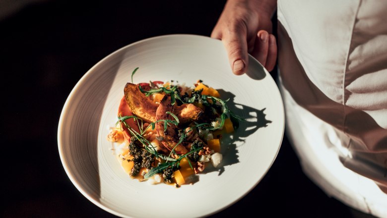 Herzlich Willkommen, © NÖ Werbung / Julius Hirtzberger Ein Teller mit einem kunstvoll angerichteten Gericht wird von einer Person in weißer Kleidung gehalten.