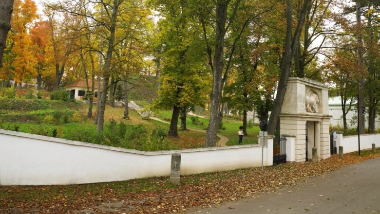 Autumnal park with trees and an archway.